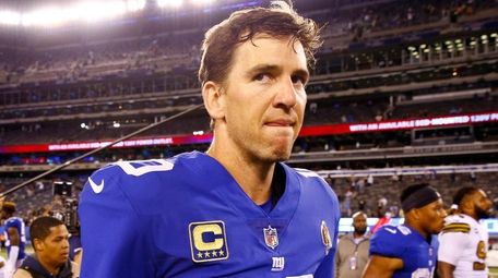 Eli Manning #10 of the Giants walks off