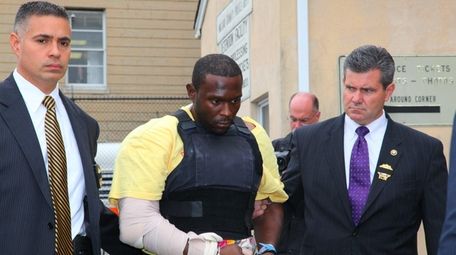 Darrell Fuller, center, leaves Nassau police headquarters in