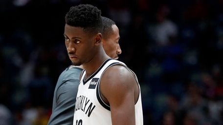 Nets guard Caris LeVert (22) walks across the