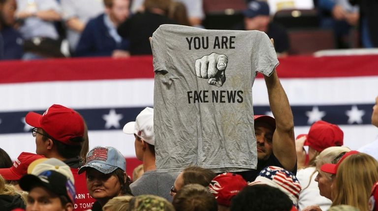 A Trump supporter holds up a T-shirt reading