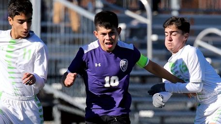Greenport's William Chapeton splits two Solomon-Schecter defenders, and