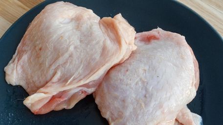 Raw chicken thighs on a plate. Federal officials