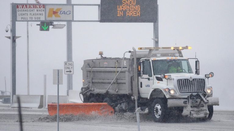 A plow removes snow at an entrance of