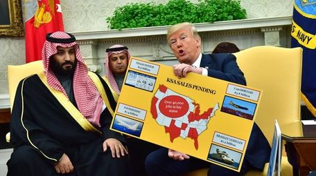 President Donald Trump (R) holds up a chart