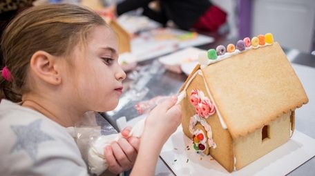 Emily Minetti works on a cookie house during