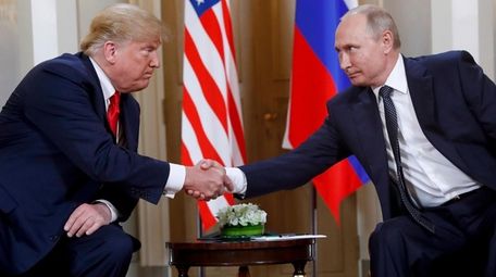 President Donald Trump shakes hands with Russian President