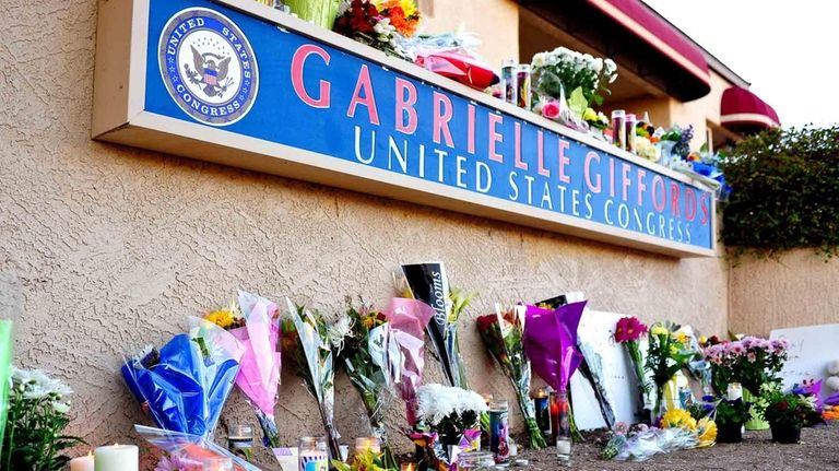 Flowers and candles are seen placed outside the