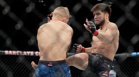 Henry Cejudo, right, kicks TJ Dillashaw during the