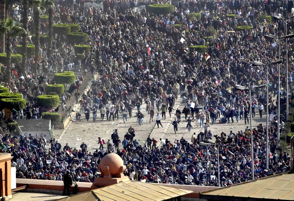 Pro-government demonstrators, bottom, clash with anti-government demonstrators, top,