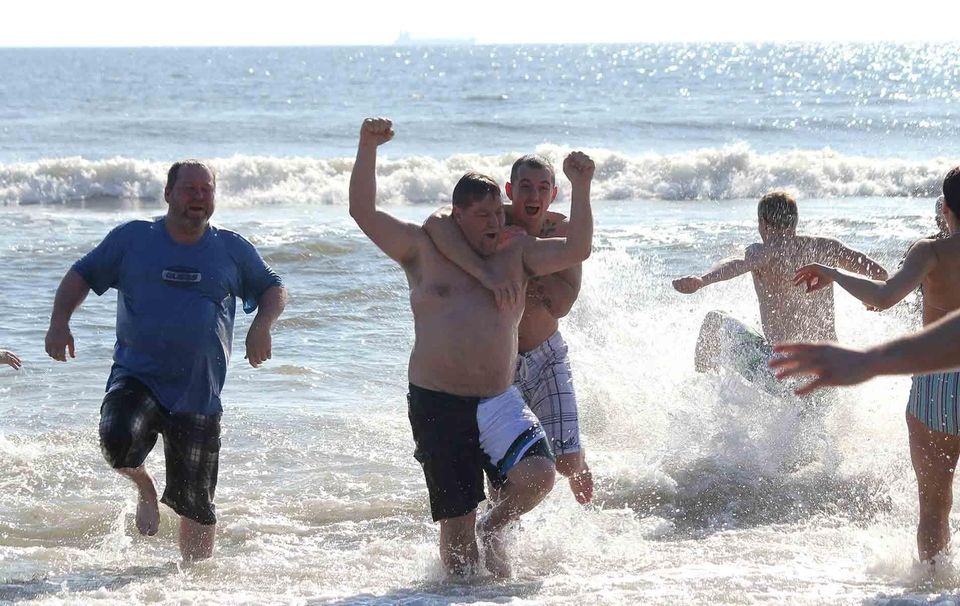 Revelers run out of the Atlantic Ocean during