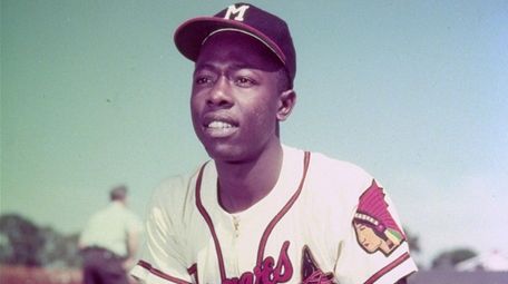 Milwaukee Braves slugger Hank Aaron kneels in the