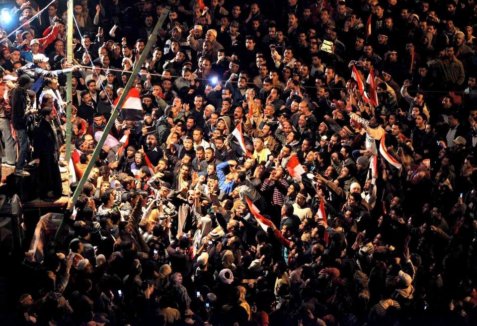 Anti-government protesters react to the televised statement made