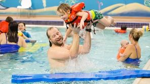 Christian Brodersen of Bellmore hoists his son, Axel,