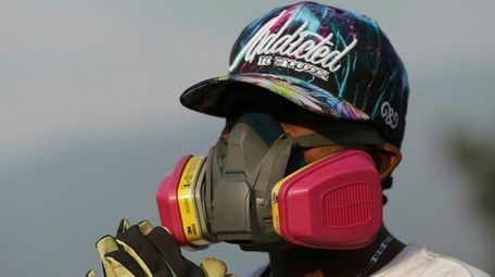 An anti-government Venezuelan migrant rests from confrontations with