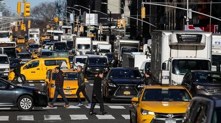 Traffic moves along 7th Avenue in Manhattan on