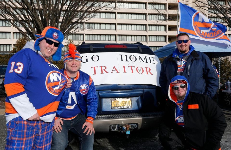 Fans pose for a photograph in front of