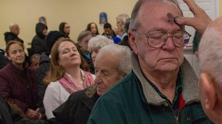 John Patterson, Westbury, receives ash as he prays