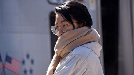 A woman uses a scarf to keep warm