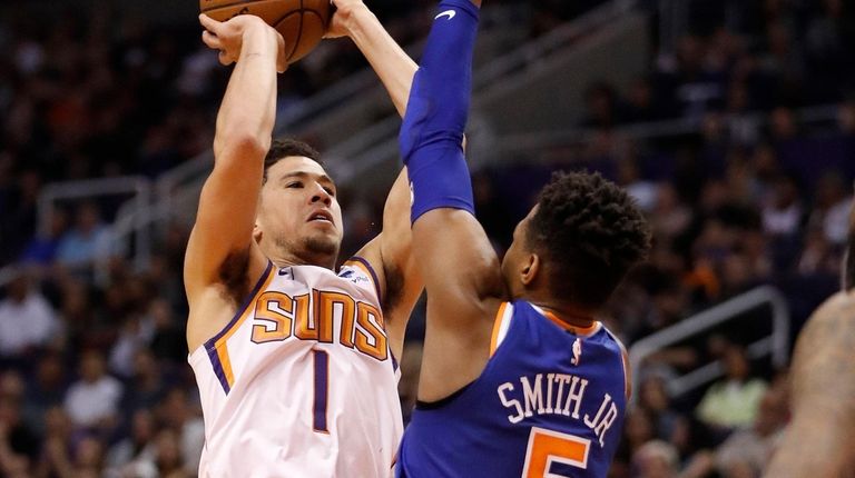 Suns guard Devin Booker shoots over Knicks guard