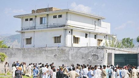 Pakistani media personnel and local residents gather outside
