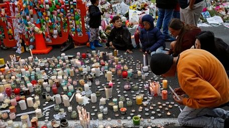 Students light candles as they gather for a