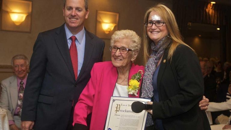 Sophie Sarro, 98, center, of Huntington Station receives