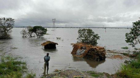 A man stands in floodwaters following cyclone-force winds