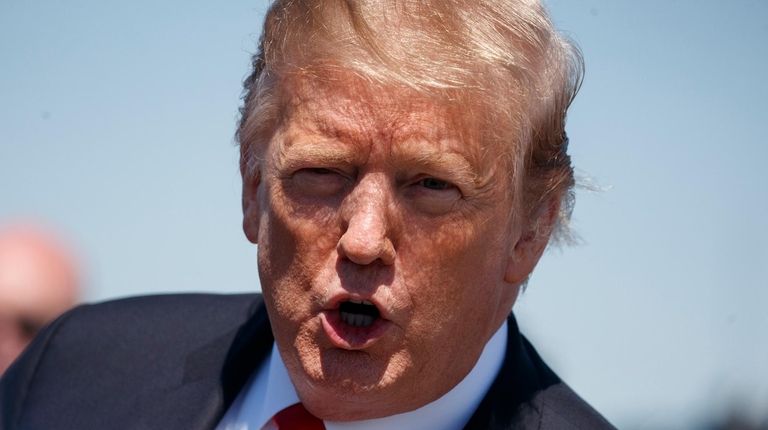 President Donald Trump calls out to reporters as... President Donald Trump calls out to reporters as