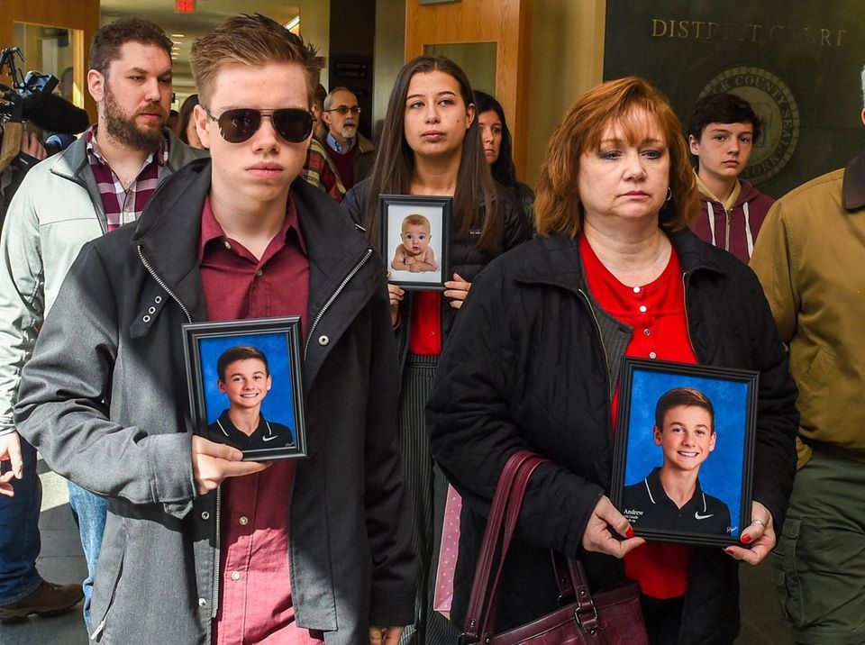 Family and friends of Andrew McMorris, hold pictures