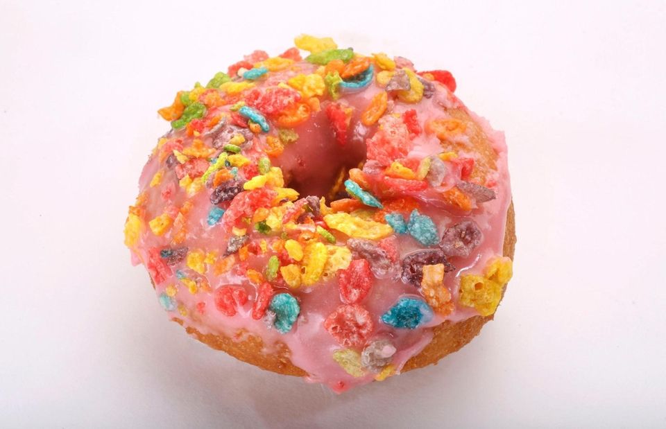 A doughnut topped with colorful cereal pieces from