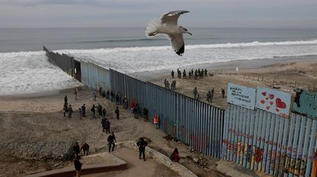 People look on from the Mexican side, left,