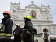 Sri Lankan firefighters stand in the area around