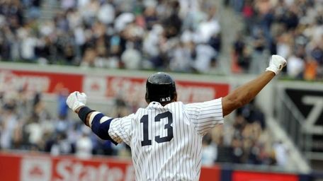 Alex Rodriguez raises his arms after hitting the