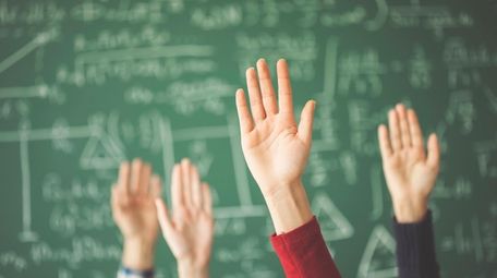 Students raised up hands green chalk board in