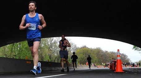 Marathoners run beneath the Sunrise Highway underpass as