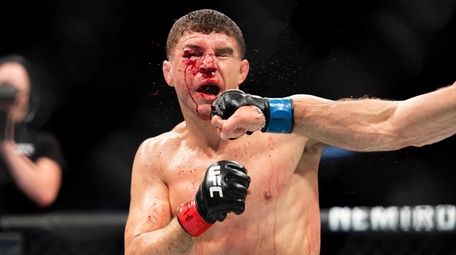 Al Iaquinta is punched by Donald Cerrone during
