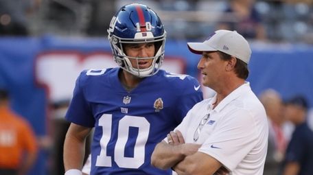 Giants quarterback Eli Manning talks with offensive coordinator