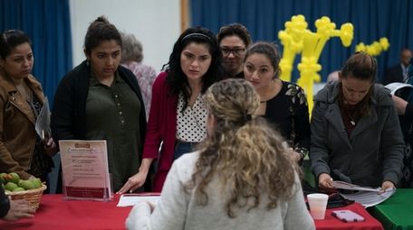 Job seekers speak with a recruiter during a