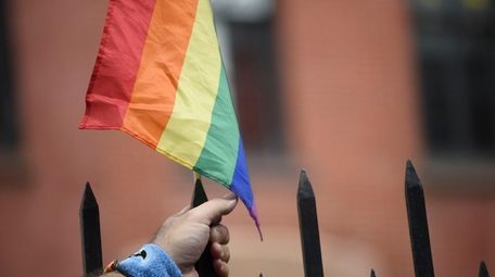 A person hold a LGBT flag during a