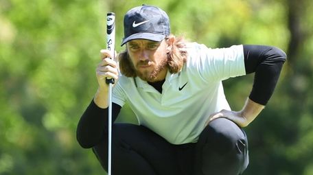 Tommy Fleetwood lines up his putt on the