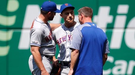 Mets rightfielder Michael Conforto, center, speaks with manager
