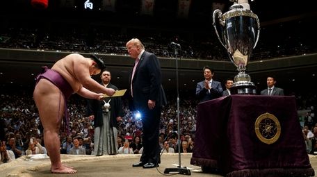 President Donald Trump presents the "President's Cup" to