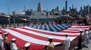 Soldiers, sailors and marines unfurl a 100-foot American