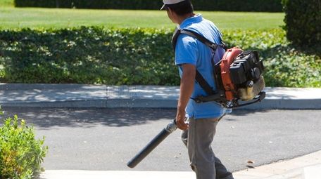 A man using a leaf blower.