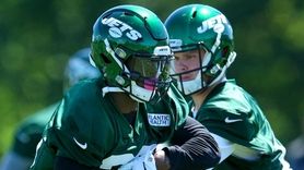 Jets quarterback Sam Darnold hands off to running
