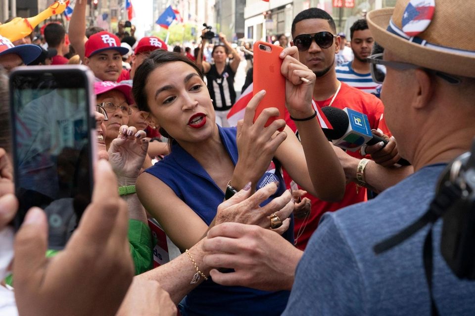 U.S. Rep. Alexandria Ocasio-Cortez takes pictures with spectators