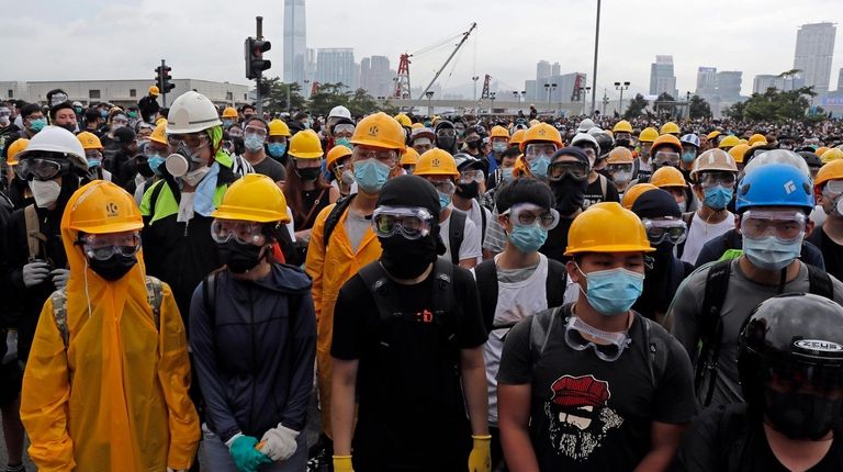 Protestors wear masks and helmets to protect their