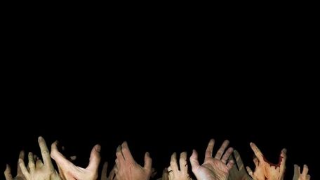 A stock photo of zombie hands reaching up