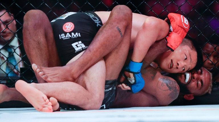 Japan's Kyoji Horiguchi, top, grapples with Darrion Caldwell