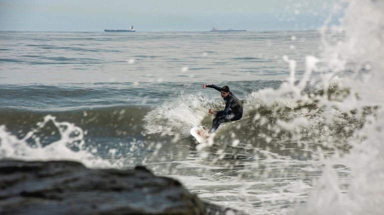 A surfer takes to the waters off Long